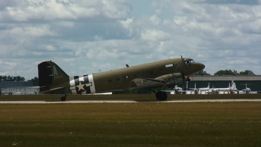 WWII transport airplane taxiing up to a runway.