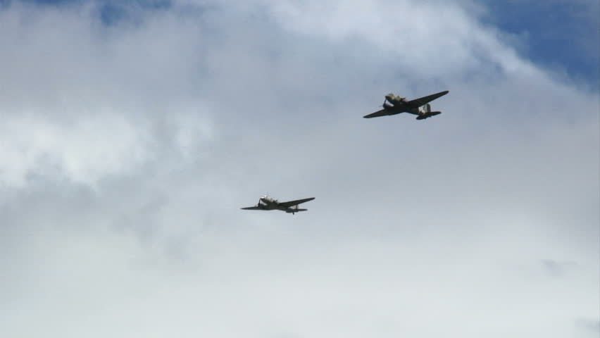 Two C-47 WWII transport aircraft flying in formation.
