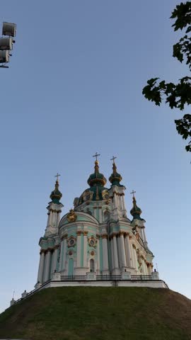 St. Andrew’s Church in Kyiv, Ukraine, featuring Baroque architecture, turquoise and white facade, golden details, onion domes and crosses under a clear blue sky.