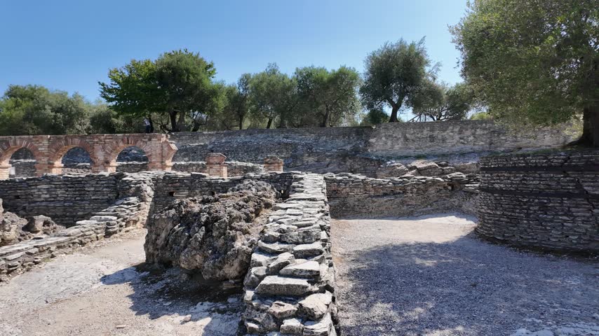 Pan shot of Roman ruins and olive trees