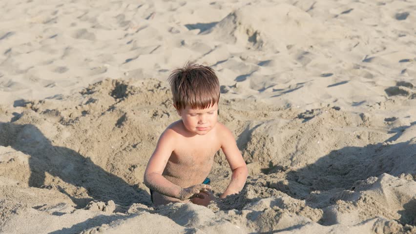 Happy Child Playing in the Sand on a Beautiful Summer Beach