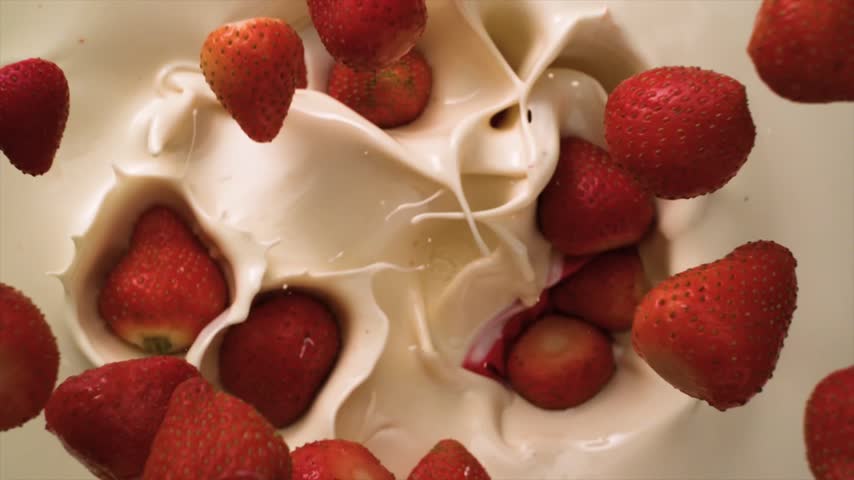 Strawberry fall in milk Slow motion