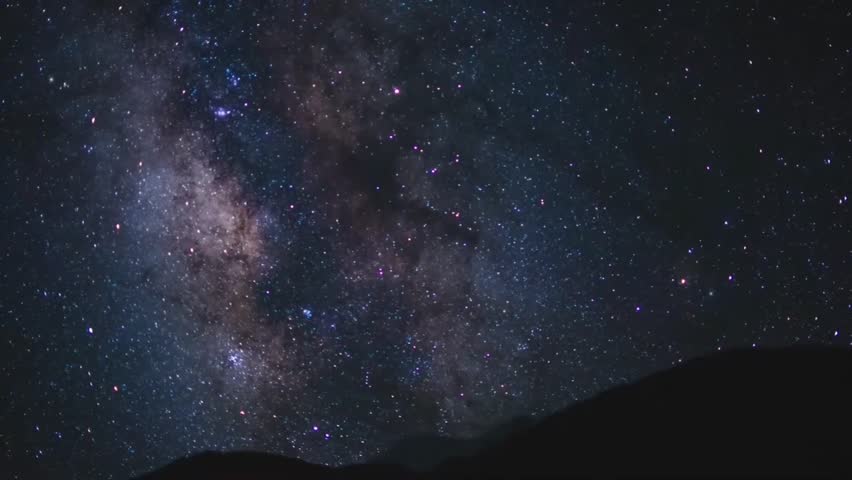 Time Lapse of Milky Way Galaxy Core Moving Across Starry Night Sky Over Mountain Silhouette