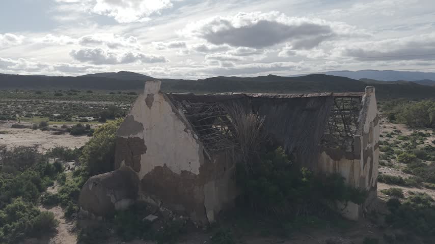 Atmospheric view of abandoned buildings with weathered walls and broken windows, symbolizing decay, forgotten history, and urban exploration themes in rural or industrial landscapes.
