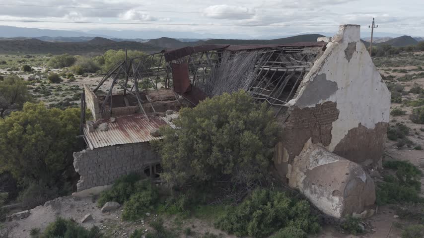 Atmospheric view of abandoned buildings with weathered walls and broken windows, symbolizing decay, forgotten history, and urban exploration themes in rural or industrial landscapes.
