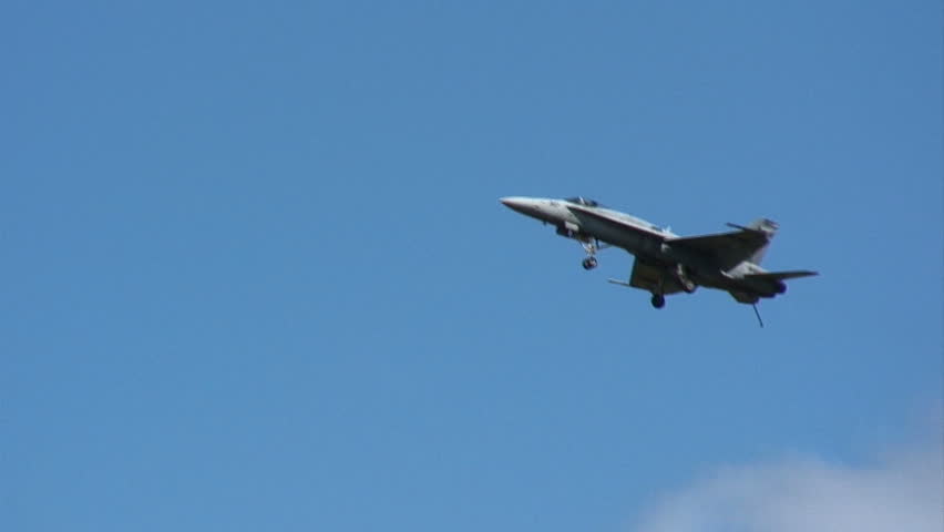 US Navy fighter jet flying with landing gear down.