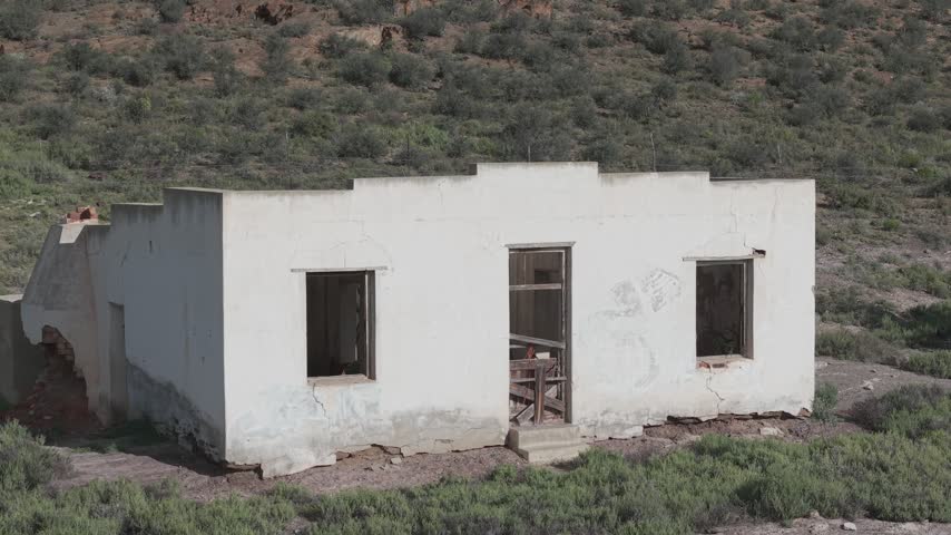 Atmospheric view of abandoned buildings with weathered walls and broken windows, symbolizing decay, forgotten history, and urban exploration themes in rural or industrial landscapes.
