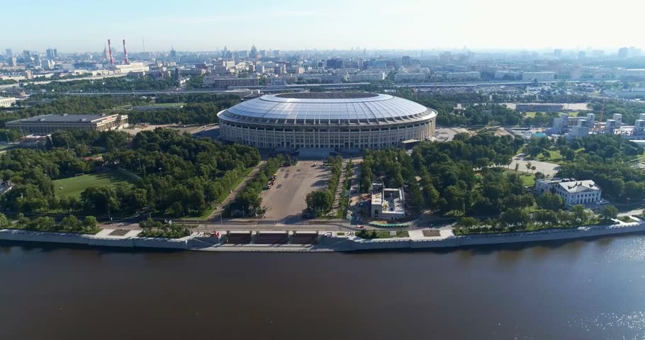 A football stadium located in the center of a busy city, surrounded by urban buildings and infrastructure, showcasing sports, architecture, and city life.