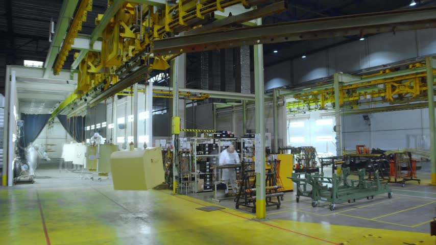 Industrial excavator manufacturing workshop with heavy machinery, factory equipment, workers, and production processes inside a modern engineering facility.