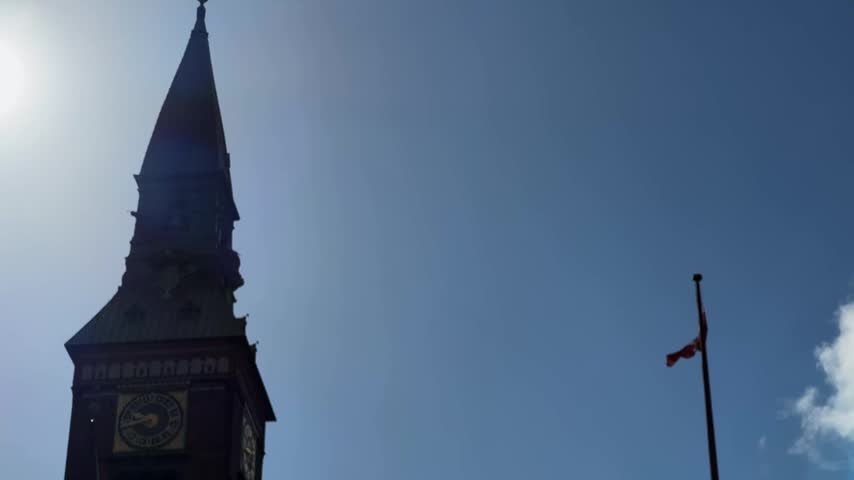 Part of the main facade of the Copenhagen City Hall building, view close-up from the City Hall Square while vertical panning at sunny summer day backlit, Denmark
