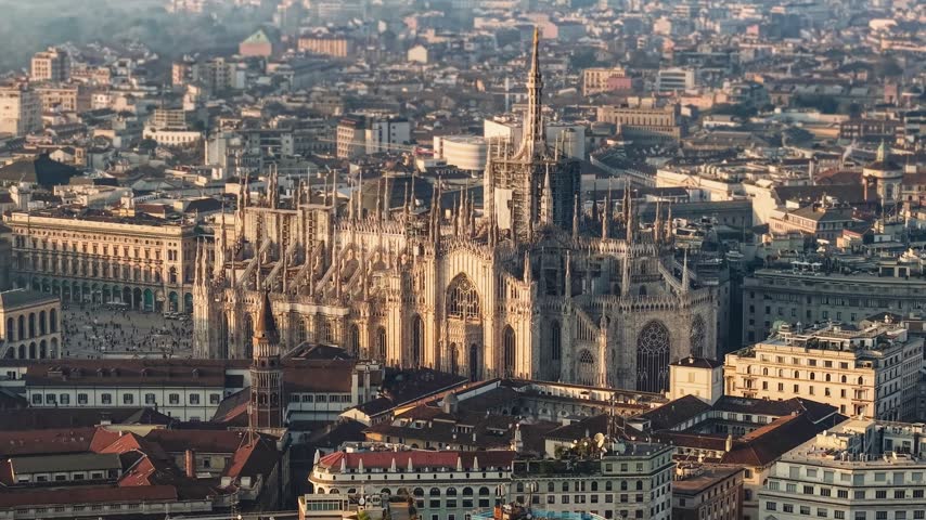 Panoramic aerial view of famous Milan Cathedral Duomo di Milano standing in city center. Gothic details of Duomo di Milano at sunset. Milan, Italy