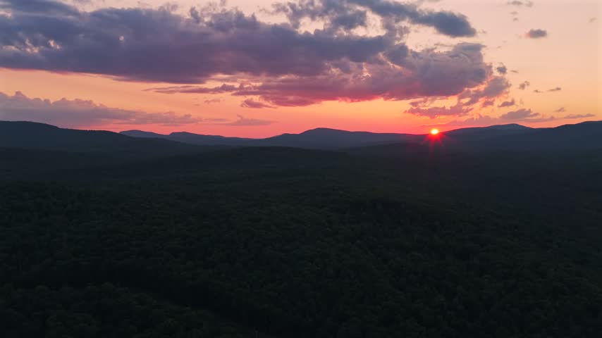 Adirondack Mountain layers Schroon Lake vibrant sunset golden hour red fire sun on horizon clouds New York State aerial drone high peaks layers Mount Severance Pharaoh Lake Wilderness forward down