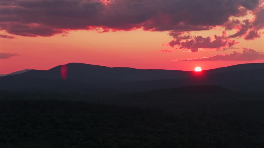 Adirondack Mountain layers Schroon Lake vibrant sunset golden hour red fire sun on horizon clouds New York State aerial drone high peaks layers Mount Severance Pharaoh Lake Wilderness circle right