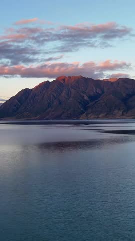 Aerial drone view of a stunning sunset over the New Zealand countryside. Scenic rural landscape with golden light.