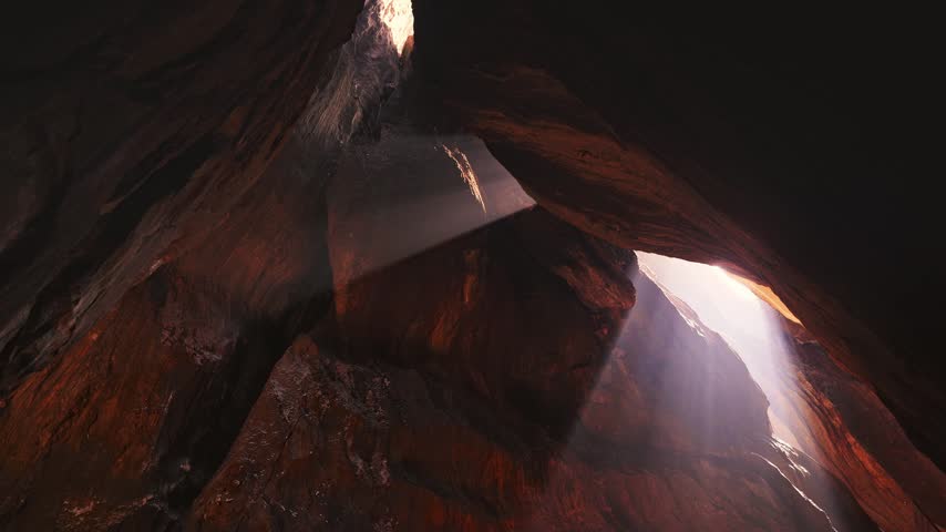 Dramatic sunlight filtering through an opening inside a cave, illuminating the textured rock walls and creating a mysterious natural atmosphere.