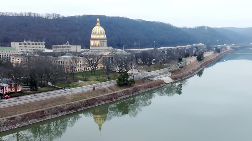 West Virginia state capitol building at dusk in Charleston, West Virginia with stable drone video.