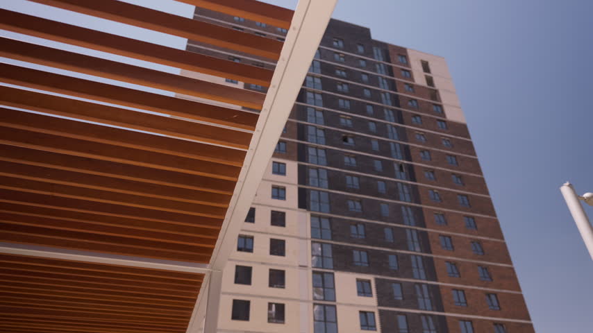 Modern high rise residential building with pergola in foreground