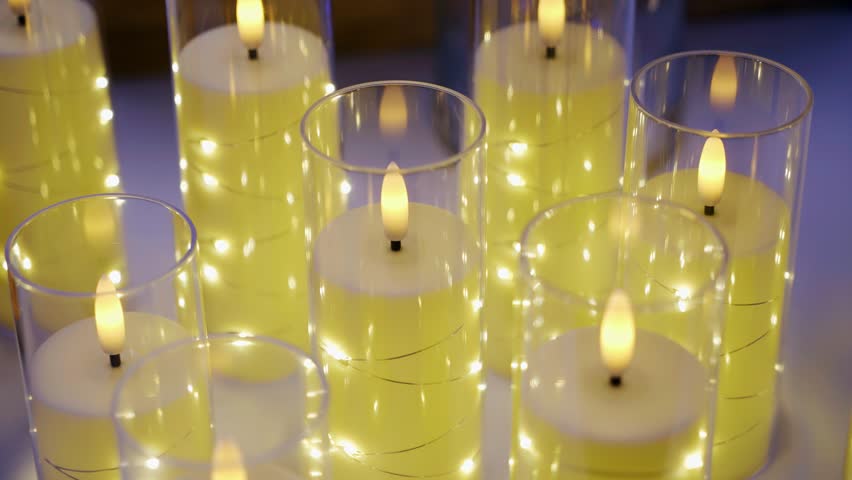 Beautiful candles in glass flasks. Close‑up shot.