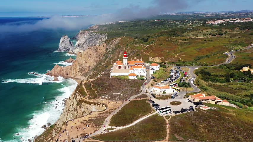 Experience Cabo da Roca from an aerial view. See the lighthouse, cliffs, ocean, and coastline of Portugal during late afternoon. Enjoy the natural beauty of the area.