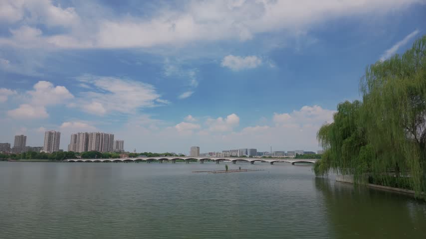 Calm lake with arched bridge and weeping willows, Baijia Lake Nanjing