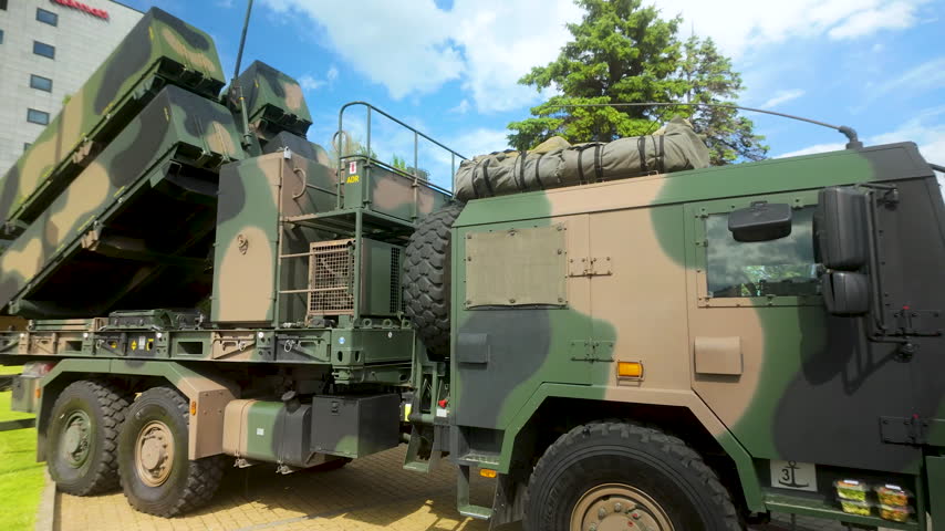 A heavy military vehicle equipped with a surfacetoair missile launcher system parked during a public exhibition. Suitable for defense, security, and geopolitical news content.