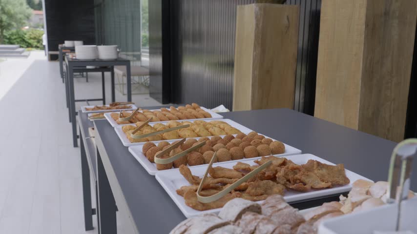 White Trays Of Croquetes Rissois And Fried Snacks With Tongs On A Grey Buffet Table