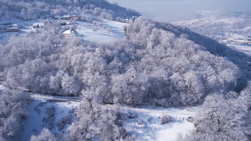 Drone Shot of Winter Fairytale Landscape, Snow Capped Forest and Village Houses on Sunny Day