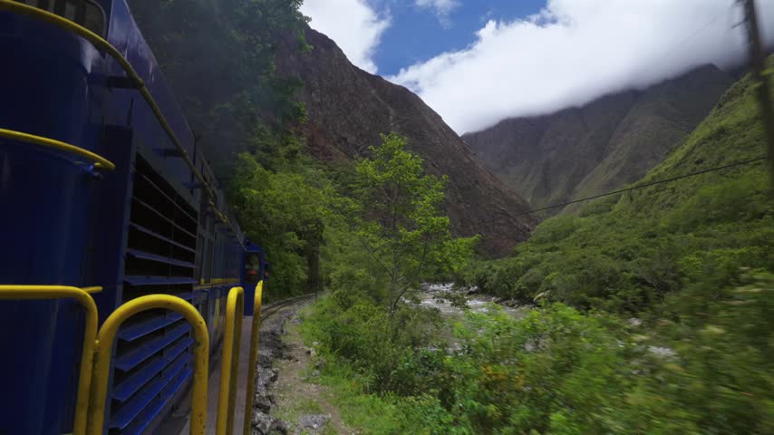 Machu Picchu train Peru Rail Sacred Valley Ollantaytambo in route Aguas Clients Amazon Urubamba river Peru Peruvian Andes mountains range peaks Inca Trail rainy season sunny blue sky clouds forward