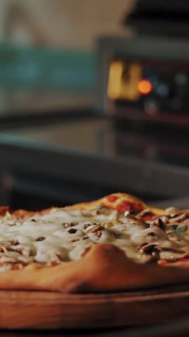 Cookery. making pizza. Close-up, The chef cuts a freshly prepared, hot pizza into pieces with a special pizza knife. process of cooking Italian pizza .