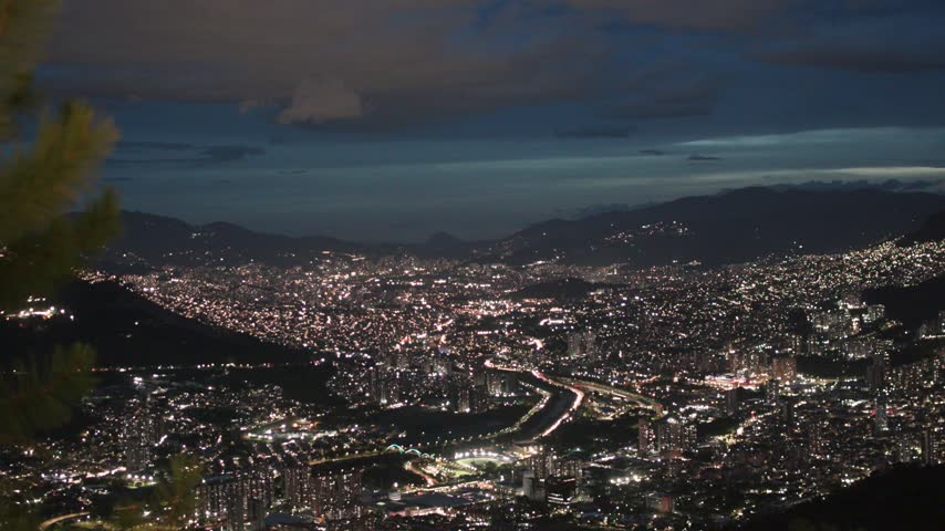 Medellín at night overlooking the illuminated Aburrá Valley, Colombia, with the city lights stretching across the surrounding mountains.