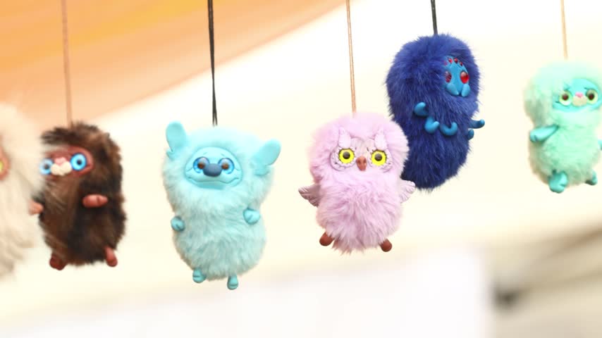 A group of stuffed animals hanging from strings, great for decoration or illustration.