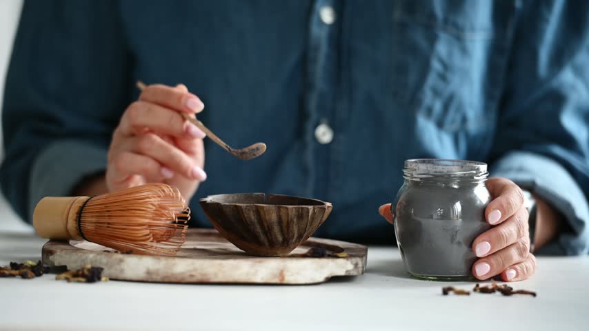 Woman Measures Tea For Making Blue Matcha Tea Into A Bowl