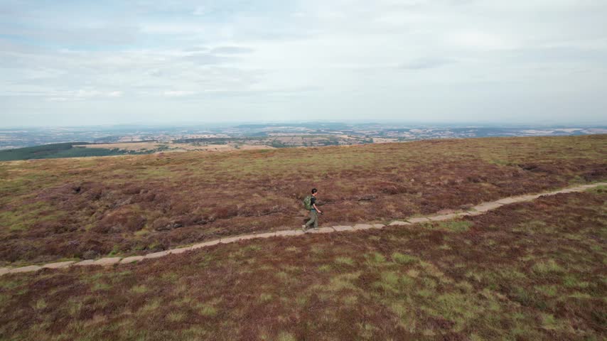 Backpacker hiker walking in Black Mountain and Twyn Llech, famous hiking location in Abergavenny, South Wales of UK.