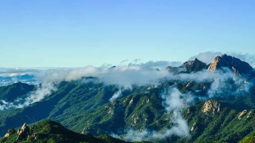 A 4K time-lapse (Zoom out) video of the summer morning landscape of Dobongsan Mountain, looking towards cloud-covered Bukhansan Mountain near Dobong-gu, Seoul, South Korea.