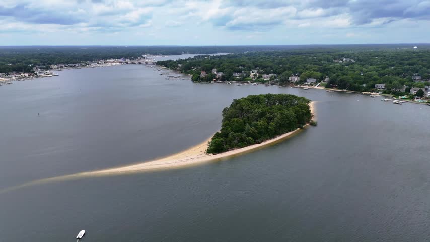 Aerial wide shot of Treasure Island, Manasquan River, Point Pleasant, partly cloudy