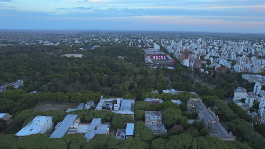 Description:
4K drone aerial view of La Plata’s Bosque at dusk, Buenos Aires, Argentina. Green parkland, Estudiantes stadium and the city’s buildings visible in the distance under the fading evening l