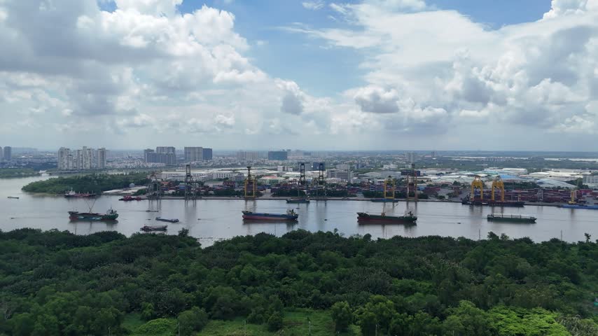Aerial view of Cat Lai Port and cargo vessels on the Saigon River in Ho Chi Minh City, Vietnam, showcasing busy maritime trade logistics.
