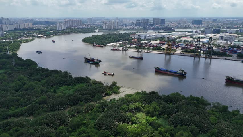 Aerial view of Cat Lai Port and cargo vessels on the Saigon River in Ho Chi Minh City, Vietnam, showcasing busy maritime trade logistics.