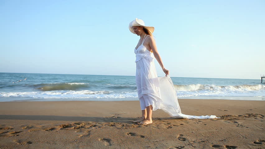 Young beautiful women in white on the beach
