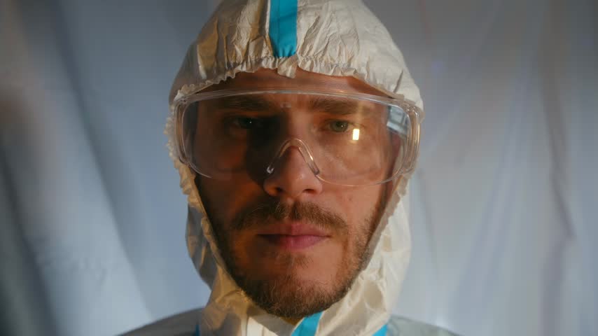 Close up bearded man in a protective suit and safety goggles eating a yellow pear, highlighting concepts of food safety, gmo testing, and scientific research in a laboratory environment