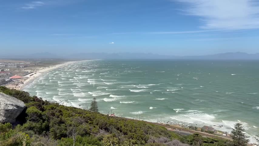 False Bay with Muizenberg beach with great waves on a windy day at Cape Town, Western Cape, South Africa, as seen from Shark Spotters Lookout