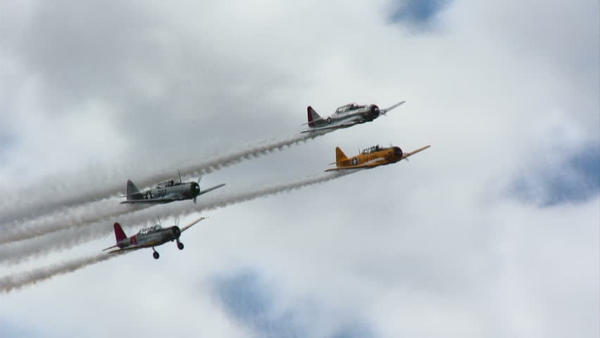 Four Republic P-47 Thunderbolts, WWII fighter planes, flying in close formation.