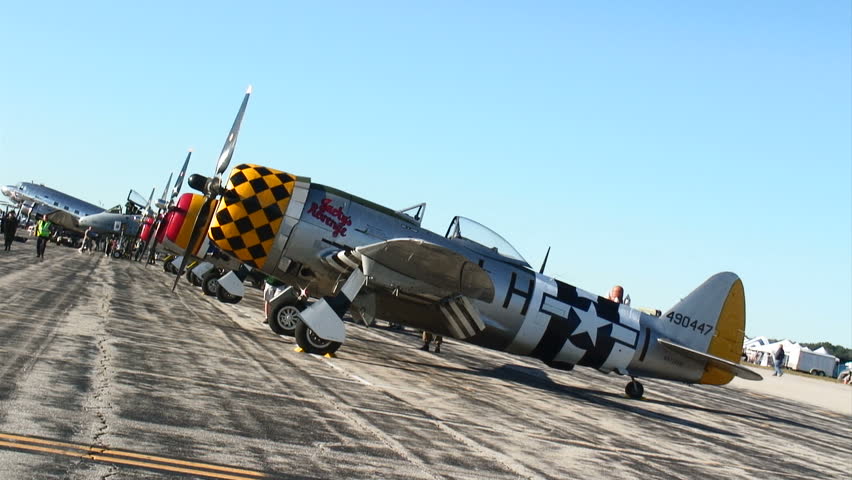 Historic P-47 Thunderbolt fighter planes lined up next to a modern A-10