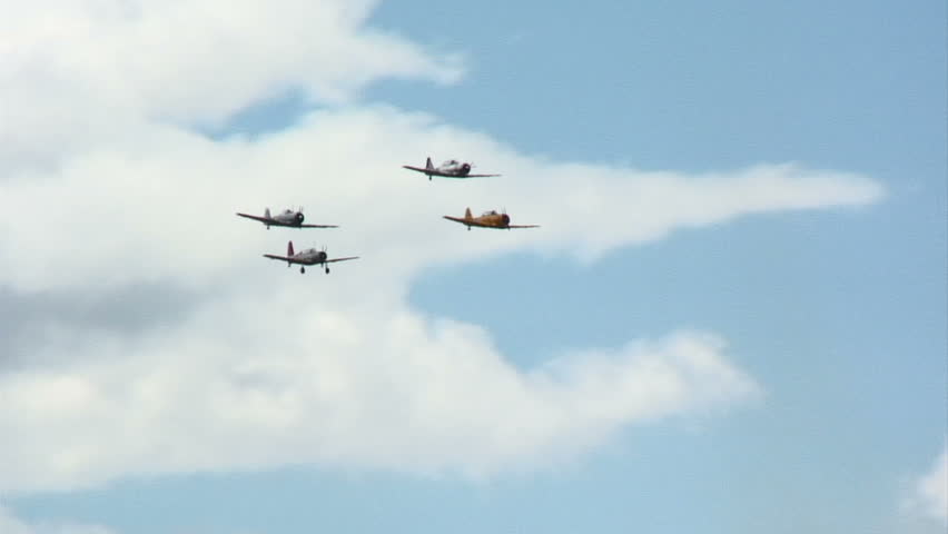 Four Republic P-47 Thunderbolts, WWII fighter planes, flying in close formation.