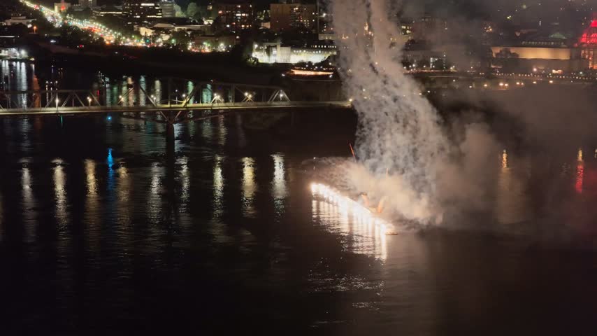 Holiday fireworks above water with reflection on the black sky background.