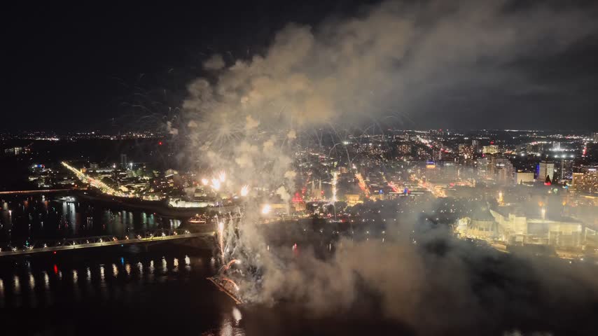 Holiday fireworks above water with reflection on the black sky background.