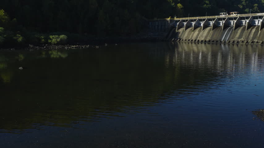 Low aerial upward angle of Remmel Dam reflected across still water, drone, Ouachita River Jones Mill Arkansas USA