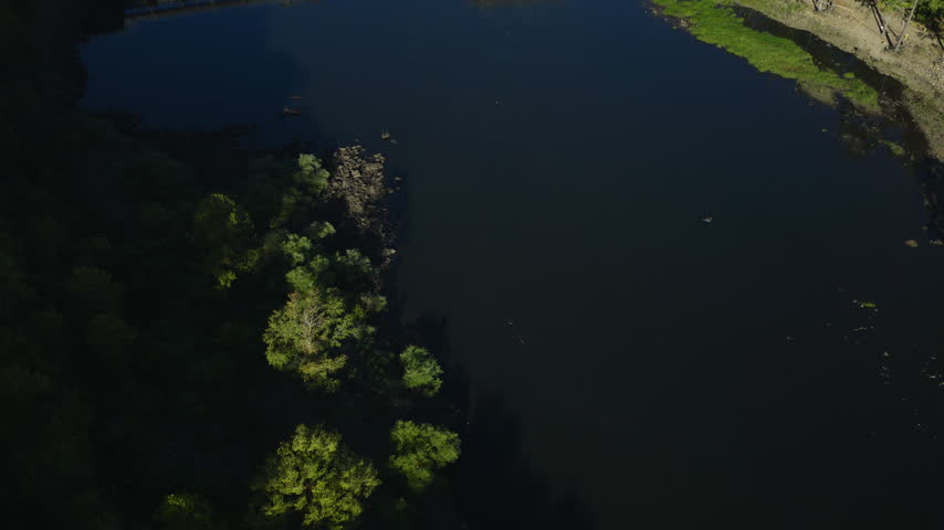 Aerial tilt upward below Remmel Dam with calm downstream water, drone, Ouachita River Jones Mill Arkansas USA