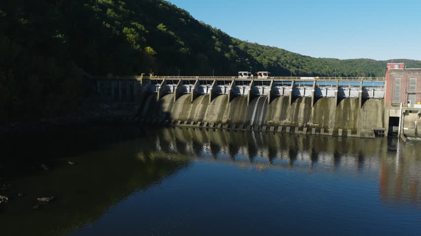 Frontal aerial pan establishing of Remmel Dam reflected in calm water, drone, Ouachita River Jones Mill Arkansas USA