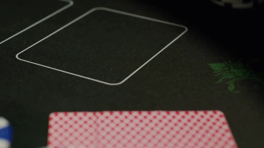 A casino poker game takes place on a green felt table with chips and playing cards, ideal for concepts of betting, gaming, risk, strategy and entertainment.
